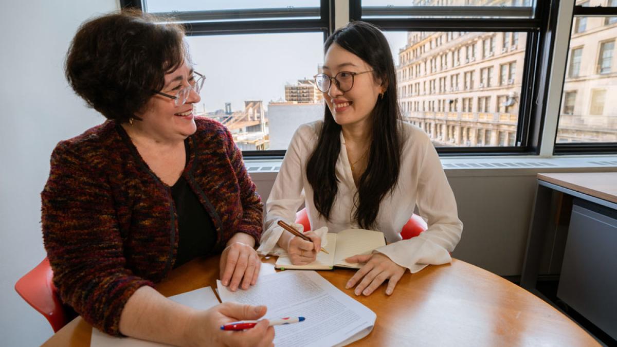 older woman and student reviewing papers at a table