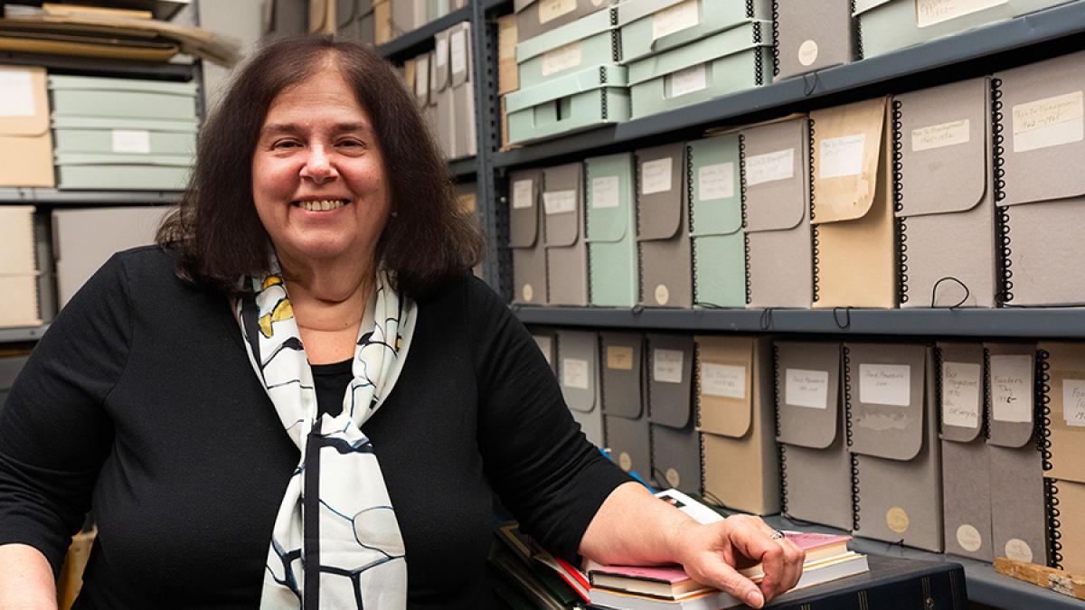 Ellen Sowchek stands in front of rows of organized files