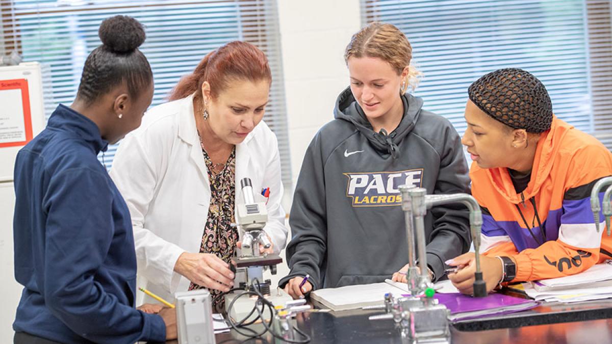 Pace University faculty member working with students in a science lab
