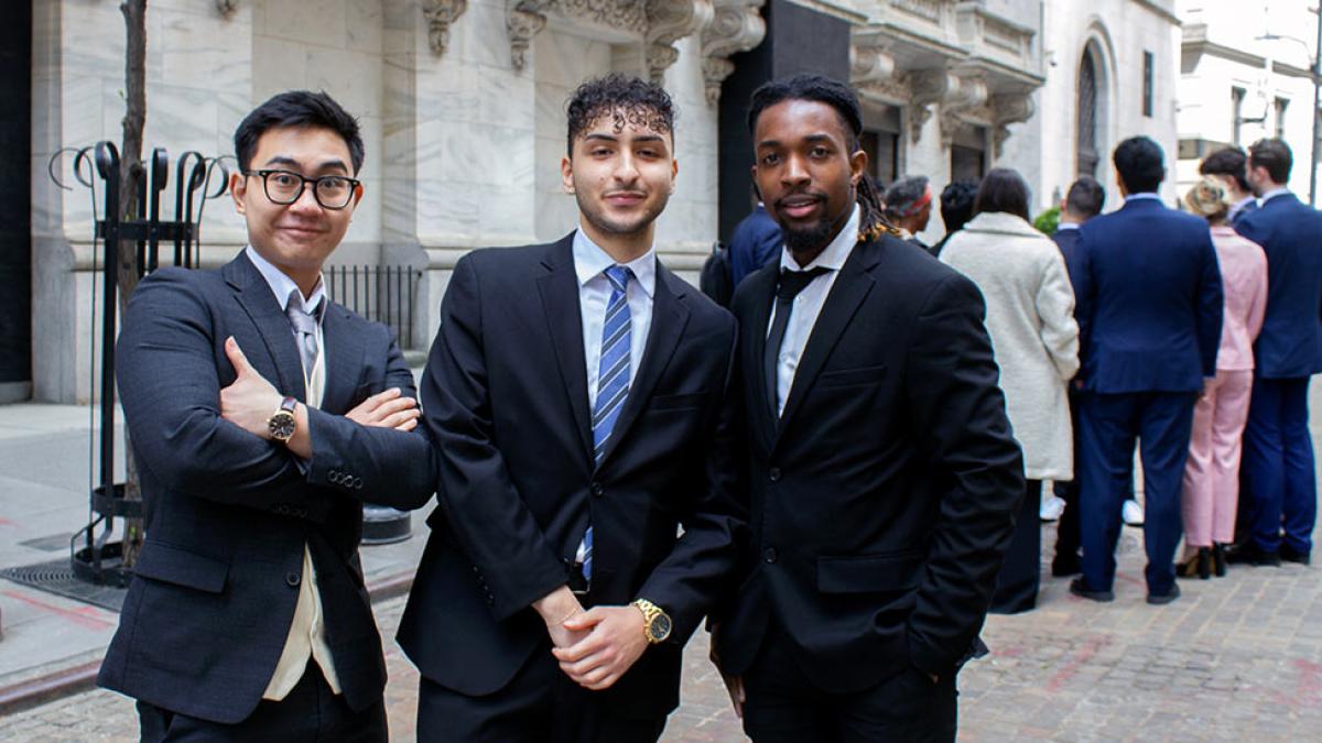 Three Pace University economics students posing in suits 