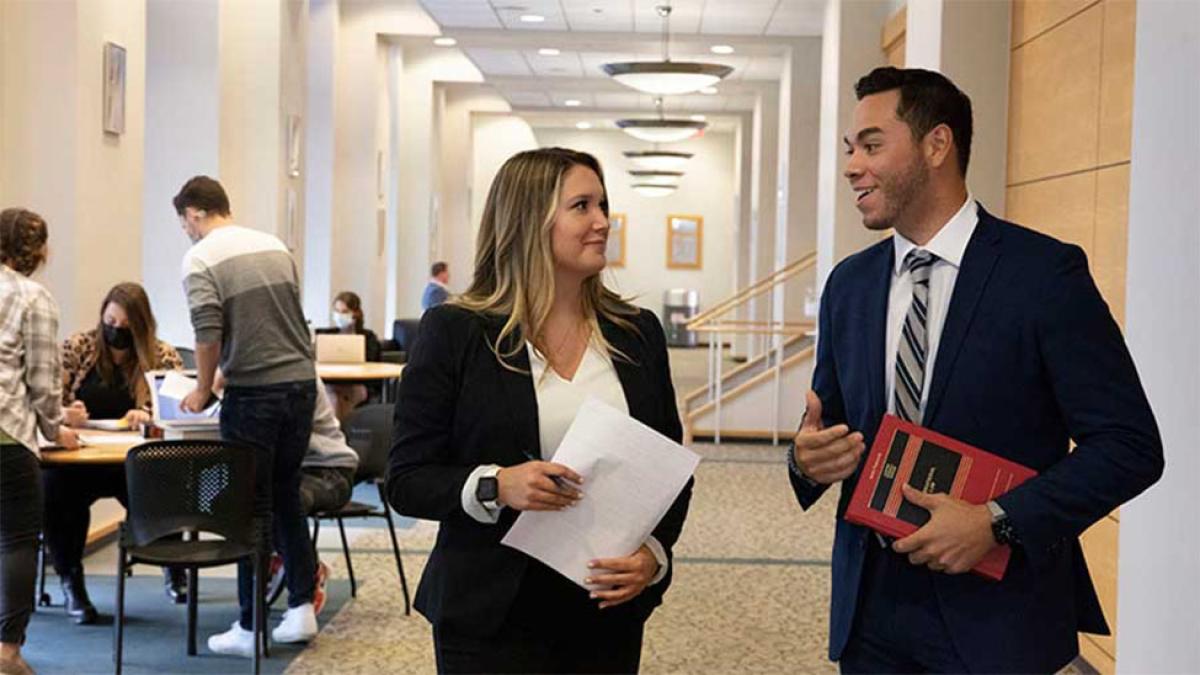 Two students conversing in hallway on the Elisabeth Haub School of Law campus