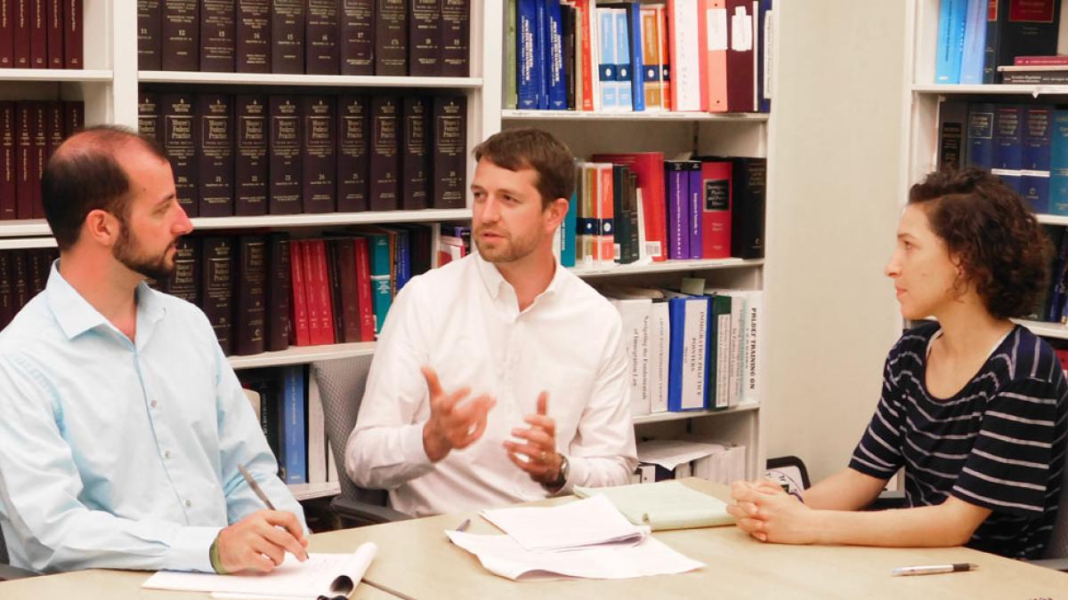 Elisabeth Haub School of Law professors speaking with each other at a table