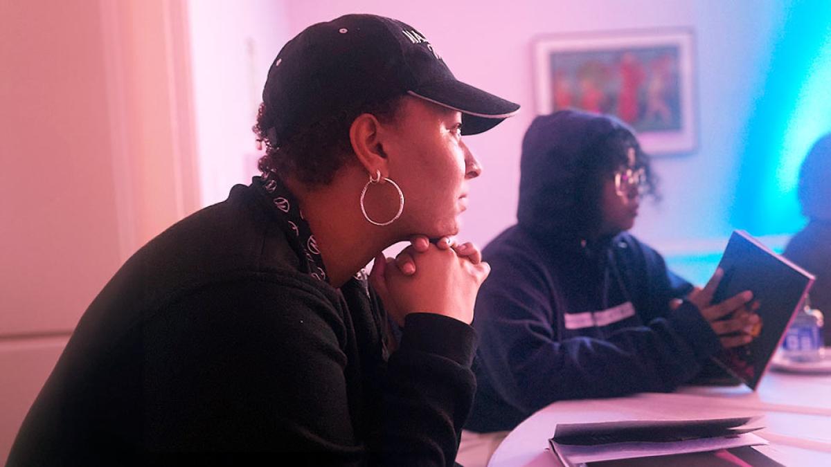 Pace University student wearing a hat and watching a presentation