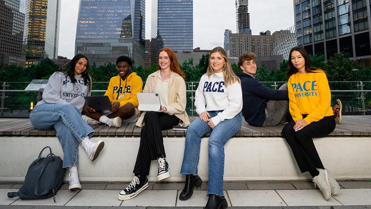 Six Pace University students sitting on a wall in Manhattan