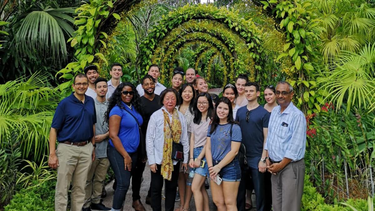 group of Lubin students standing with Prof. Gopalakrishna in a tropical garden in Singapore 