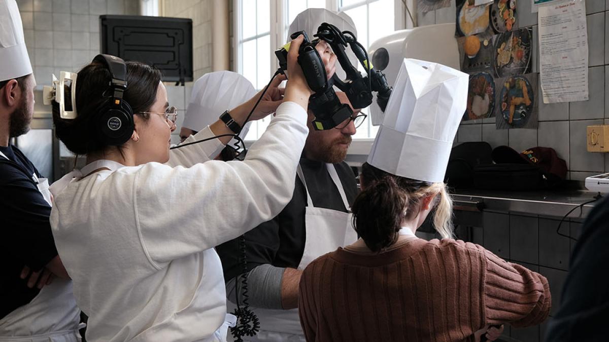 Pace University student filming chefs in a kitchen