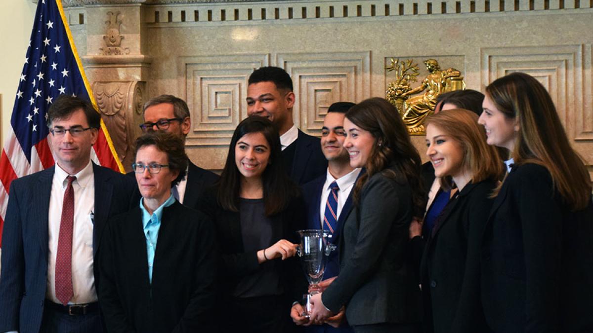 Group of Pace University economics students on the Federal Reserve Challenge Team holding trophy