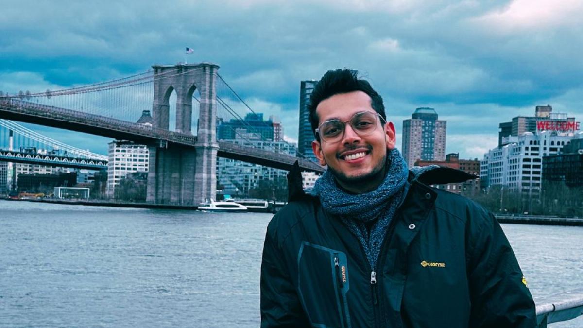 Seidenberg student Nishant Doshi stands before the Brooklyn Bridge on a cloudy day