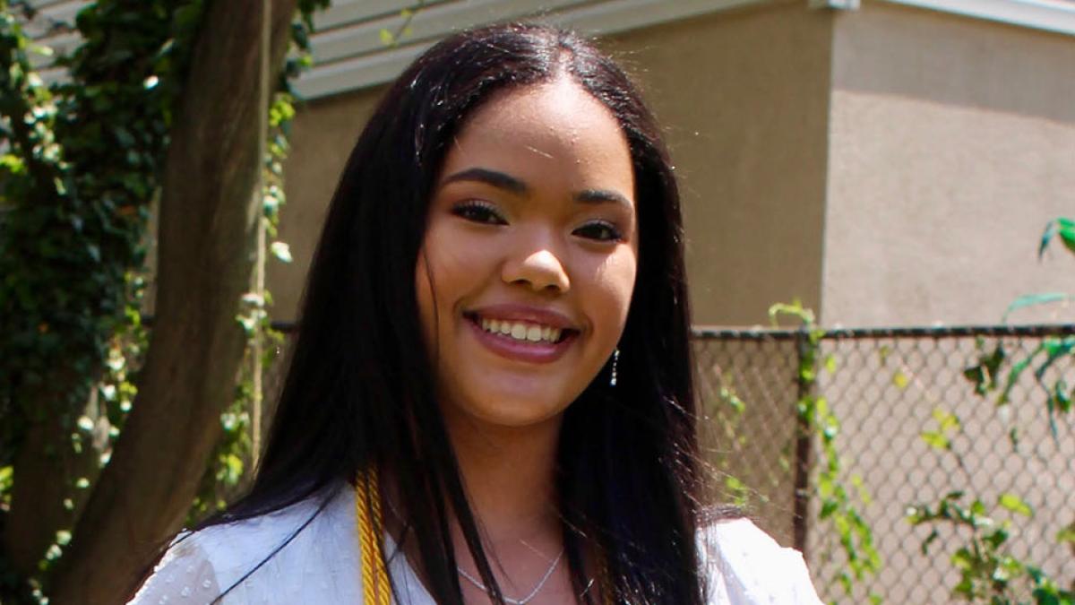 Pace student Valentina Rojas Abreu smiles in front of a home