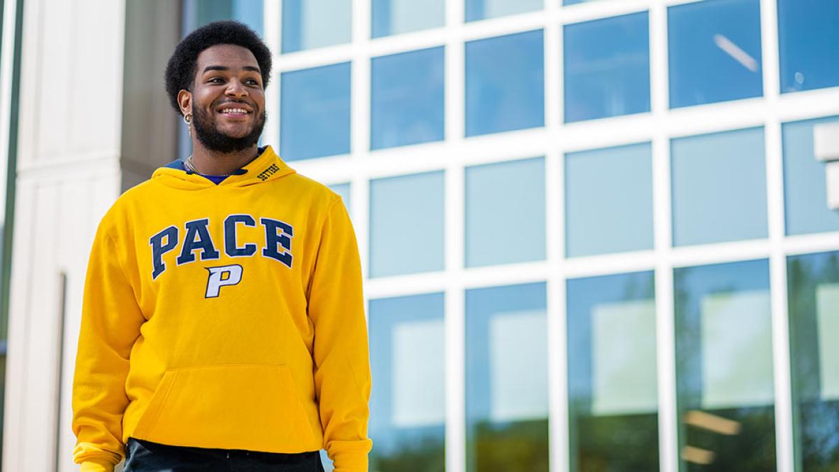 Pace Student D'Andre Butler wears a yellow Pace sweatshirt