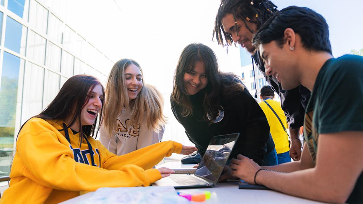 Pace university students looking at a computer.