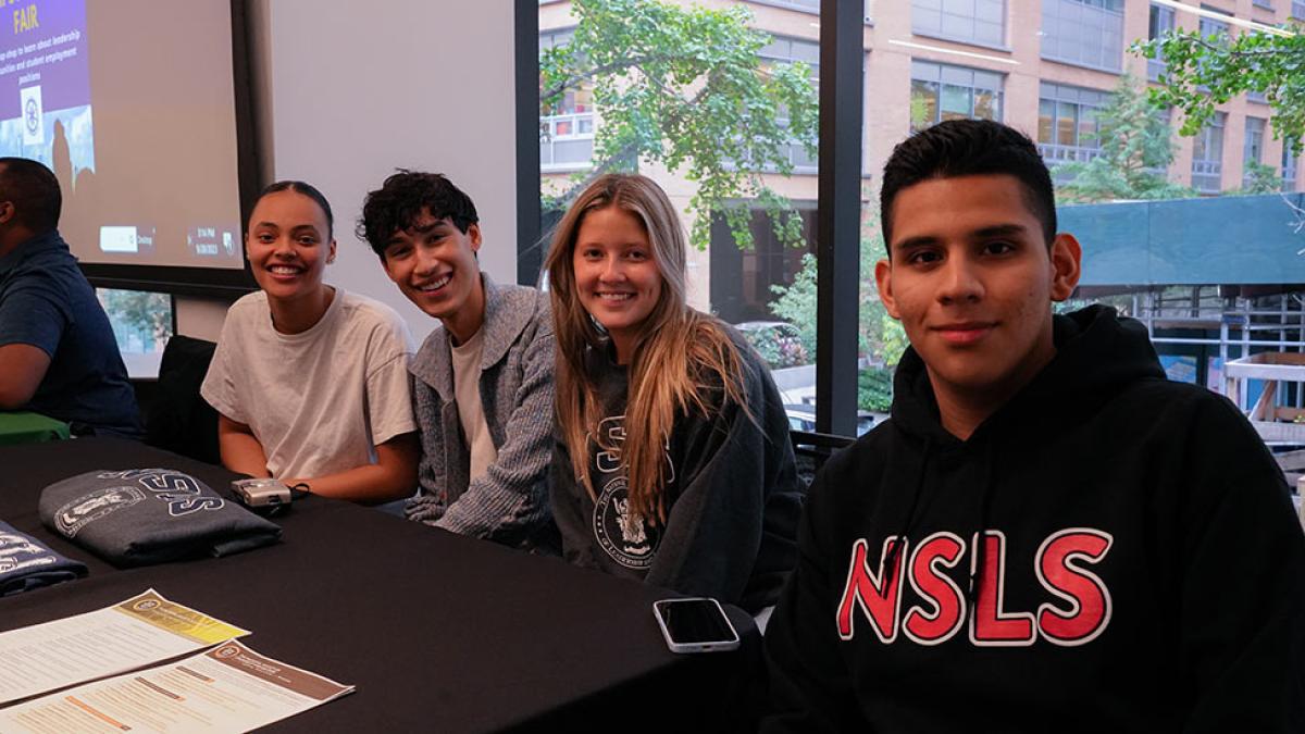 Pace university students sitting at a table.