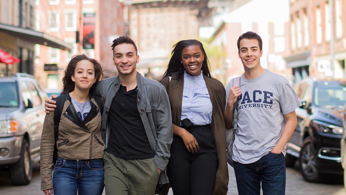 4 pace university students walking down a street in NYC.
