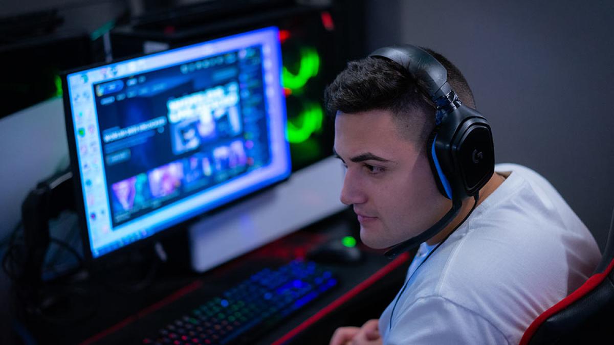 a Pace esports student wears a headset at his gaming station