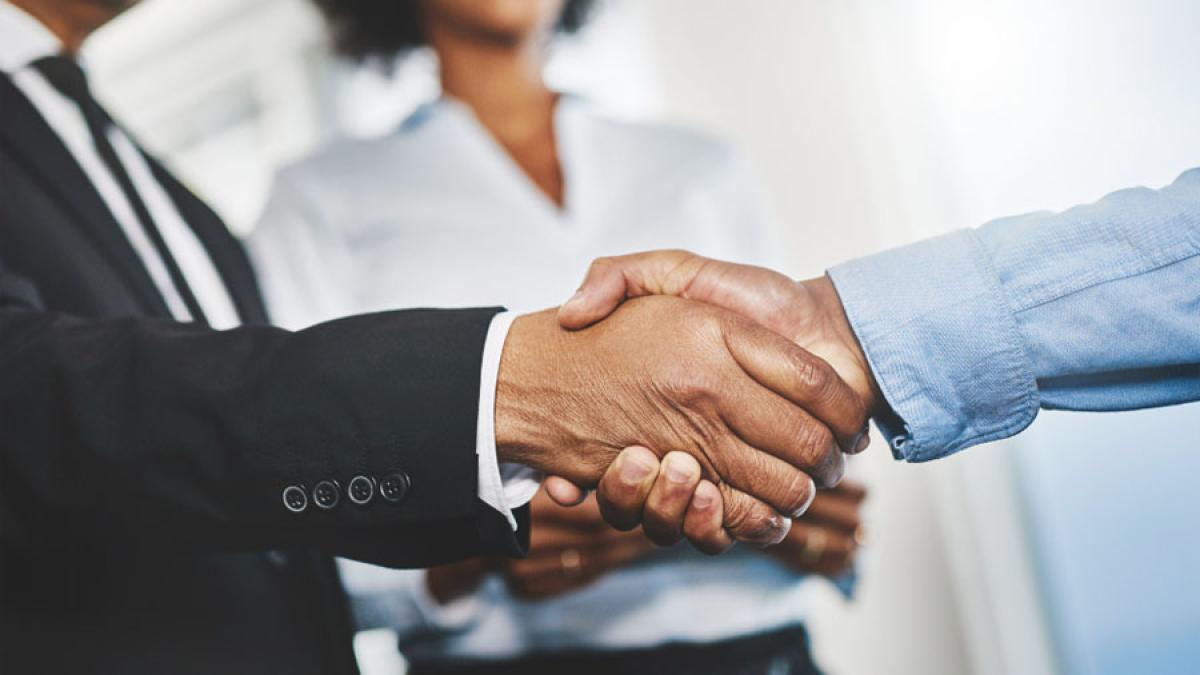 close view of two people in business attire shaking hands