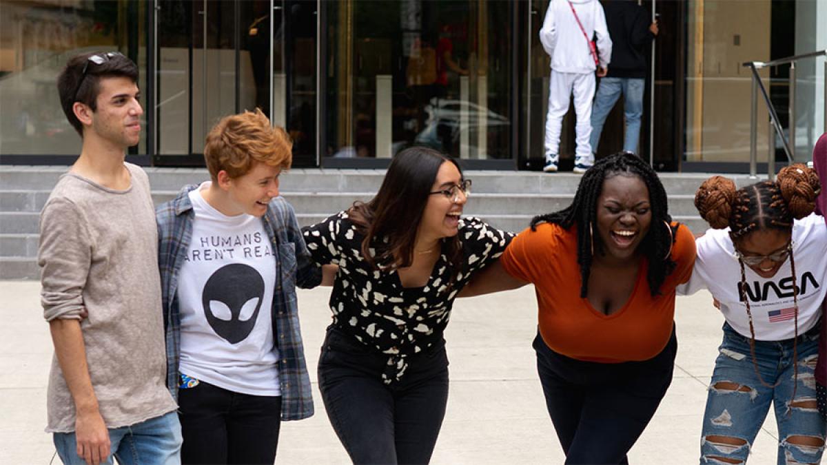 Group of Pace University students hugging and smiling.