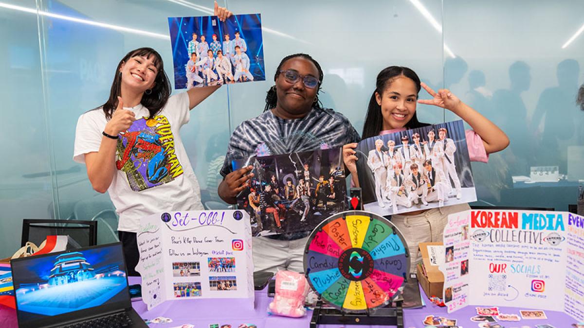 Pace University students at a display table. 