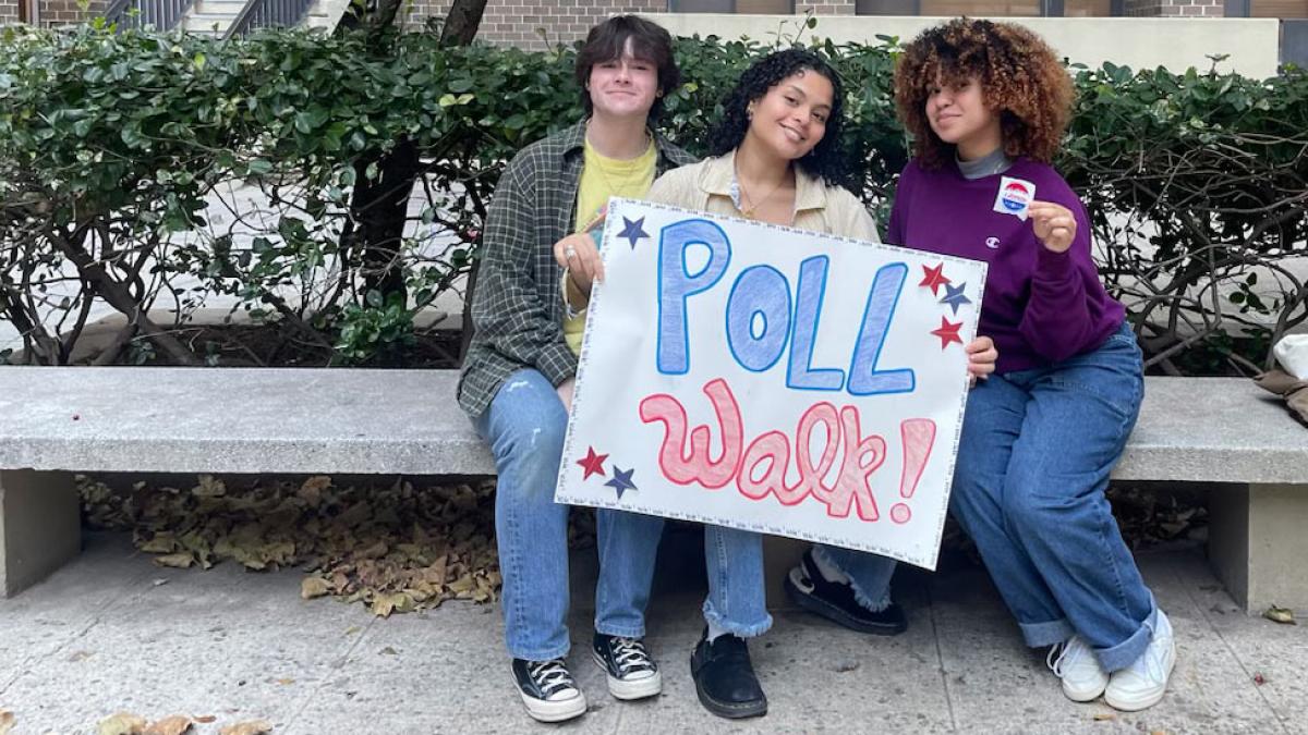 Pace students posing for the camera holding a sign that says Poll Walk