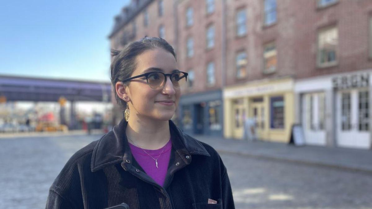 Pace Student Lauren DeMaio standing in front of old buildings in Seaport, NYC.