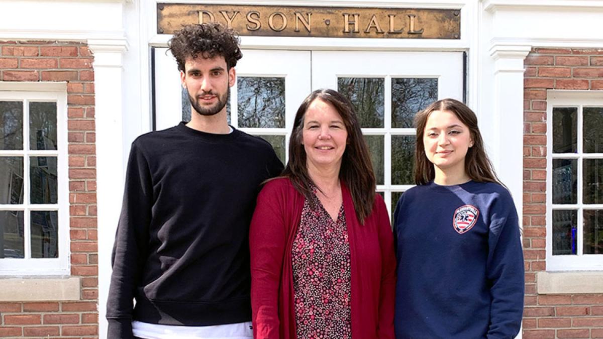 Pace University's Biology Professor Nancy Krucher standing on the steps in front of Dyson Hall with students Michael Feretti and Anastasiia Vaska who assisted in cancer treatment resistance research