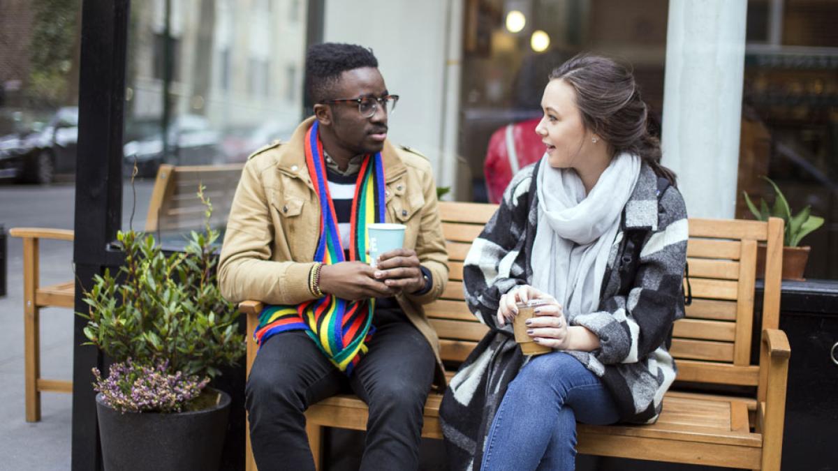 Pace University students sitting on a bench enjoying a coffee in New York City