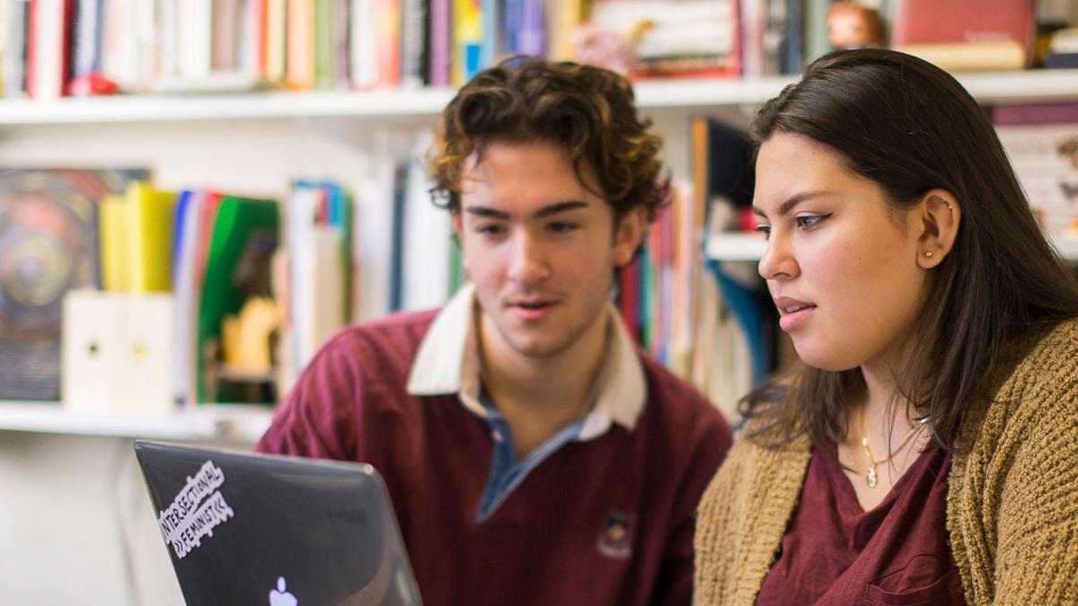 Pace University students studying in front of a computer