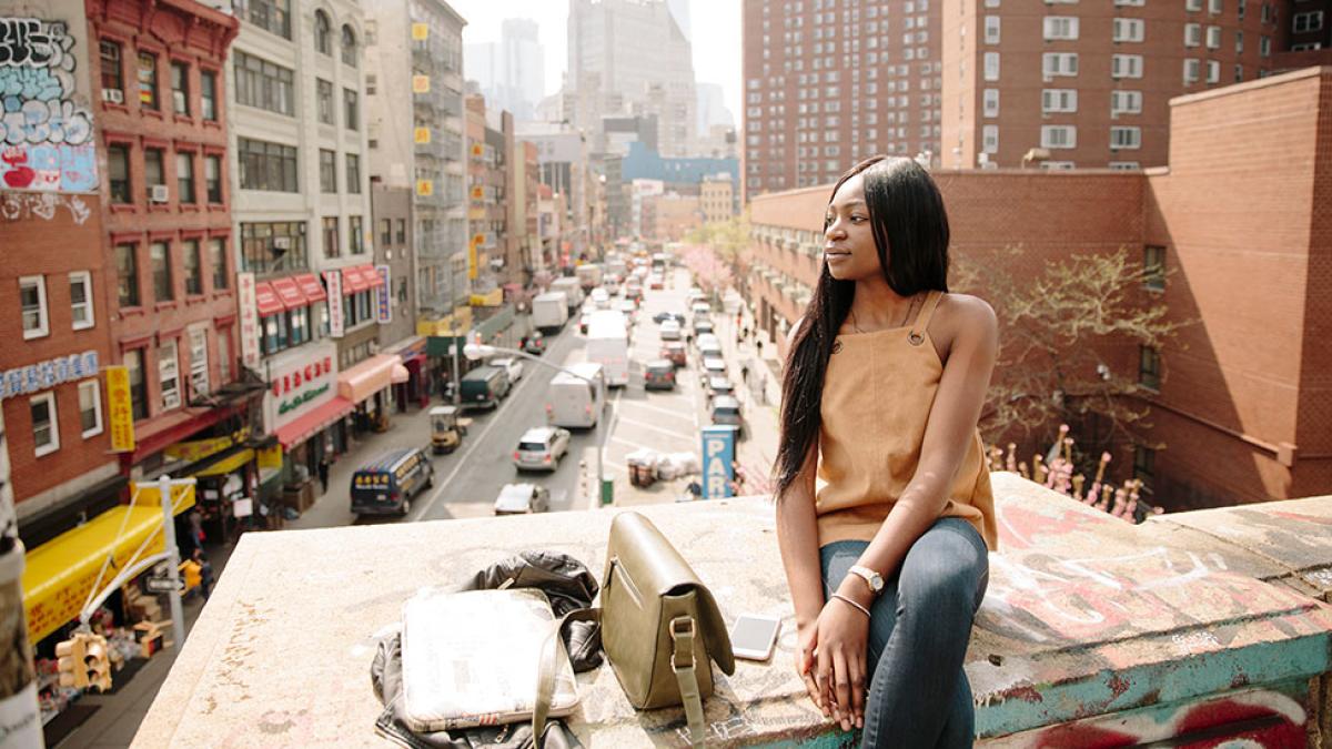 Prospective Pace University student sitting on a rooftop in NYC