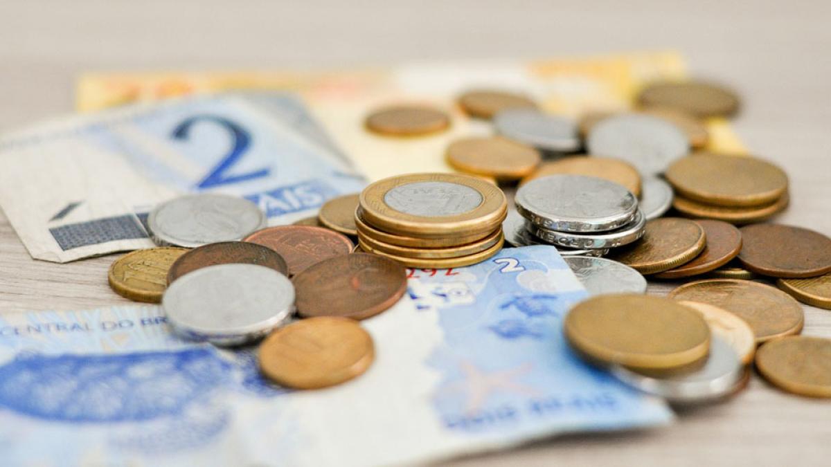 pile of international coins, notes, and currency used by world travelers