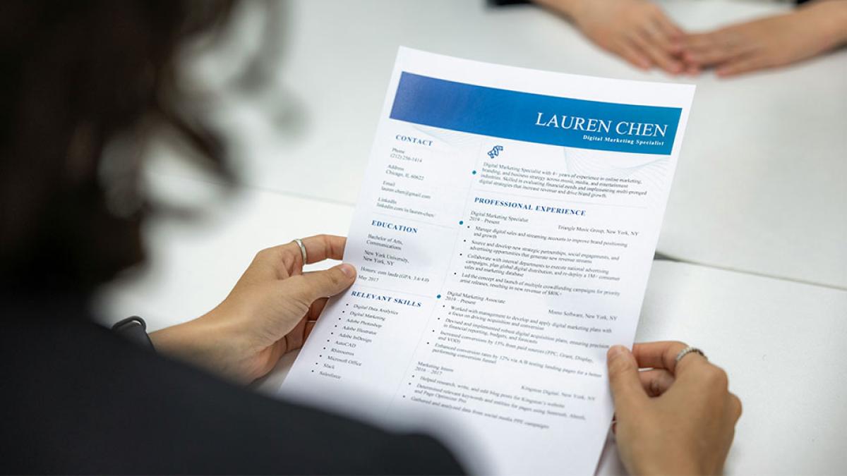 Over the shoulder photo of a woman viewing a resume.