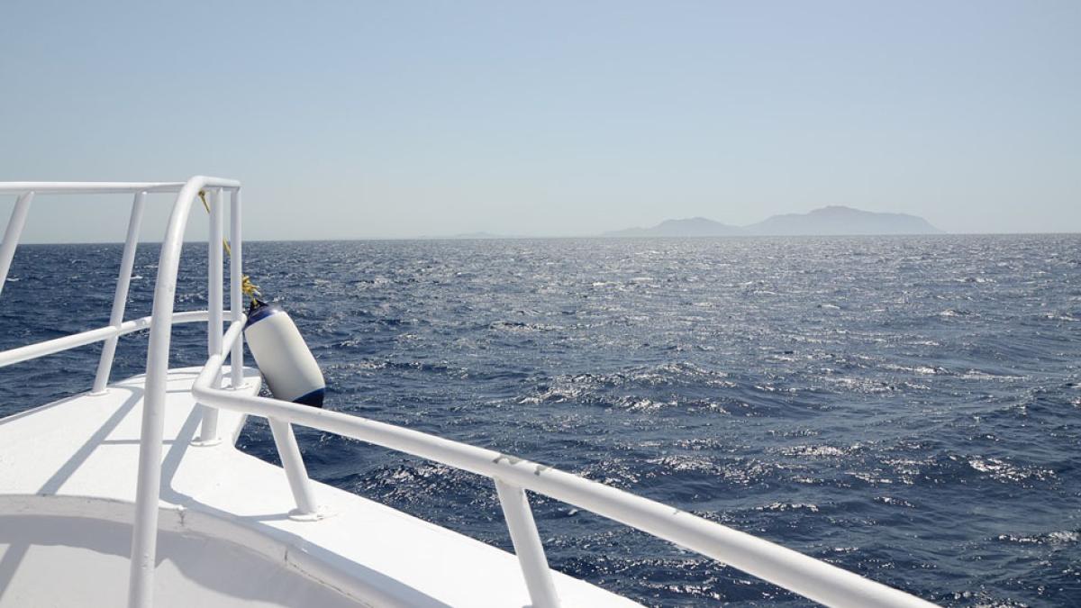 close view of the front of a cruise ship with railing and sea in background