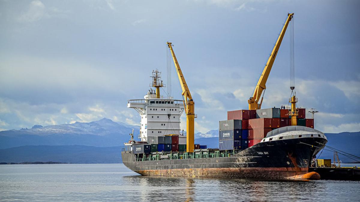 cargo ship in harbor with cranes and shipping containers