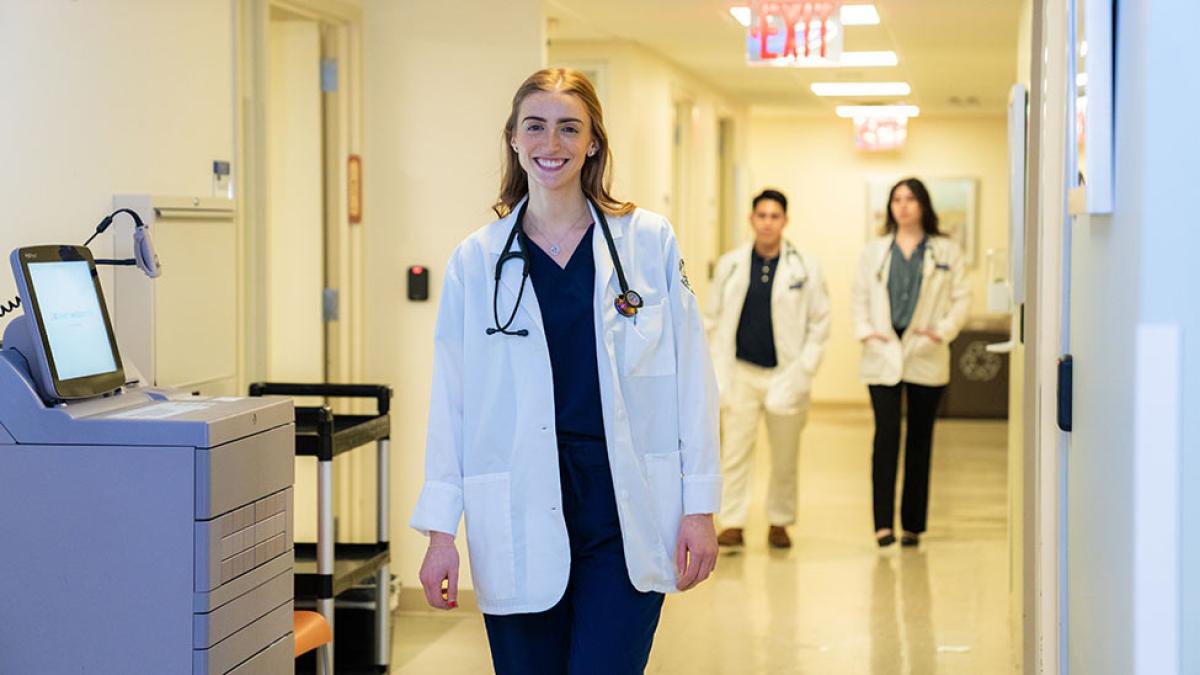 Pace University nursing student walking down a hallway.