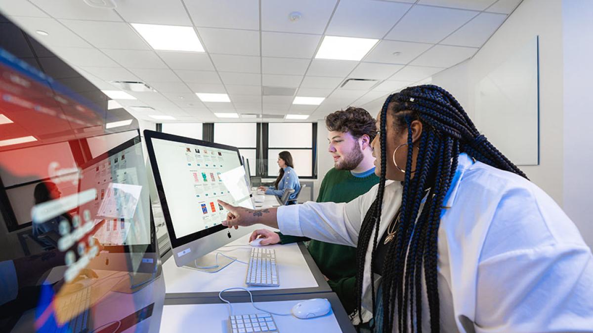 Two Pace University students looking at a computer screen.