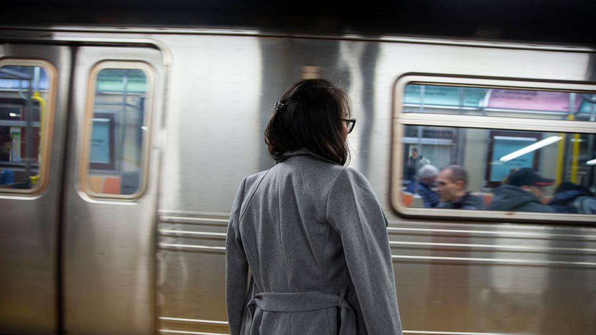 Pace University student waiting on a subway platform in New York City.