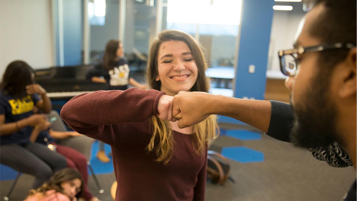 Two Pace University students fist-bumping on the Pleasantville Campus. 