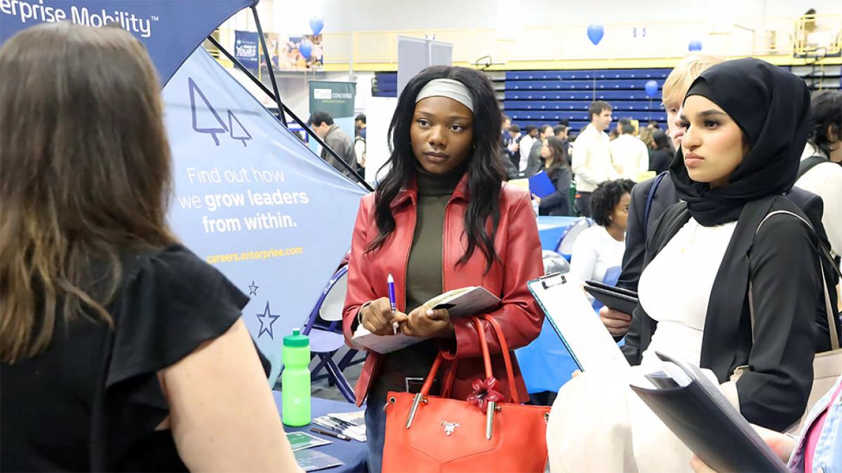 Two Pace University students talking to a job recruiter at the 2025 Spring Career Fair.