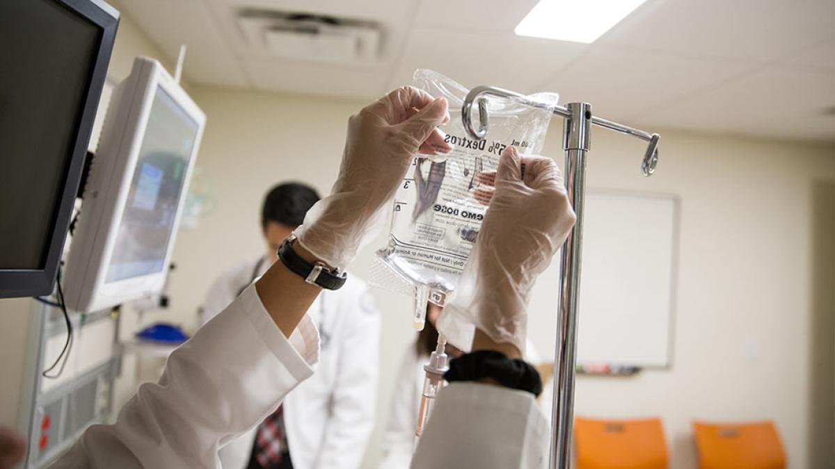 College of Health Professions Physician Assistant Pleasantville student setting up an IV bag.
