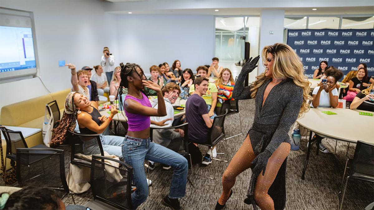 Pace University students and bingo host high five at a student activities bingo event