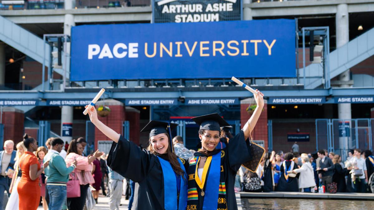 Pace University graduates posing with their diplomas.