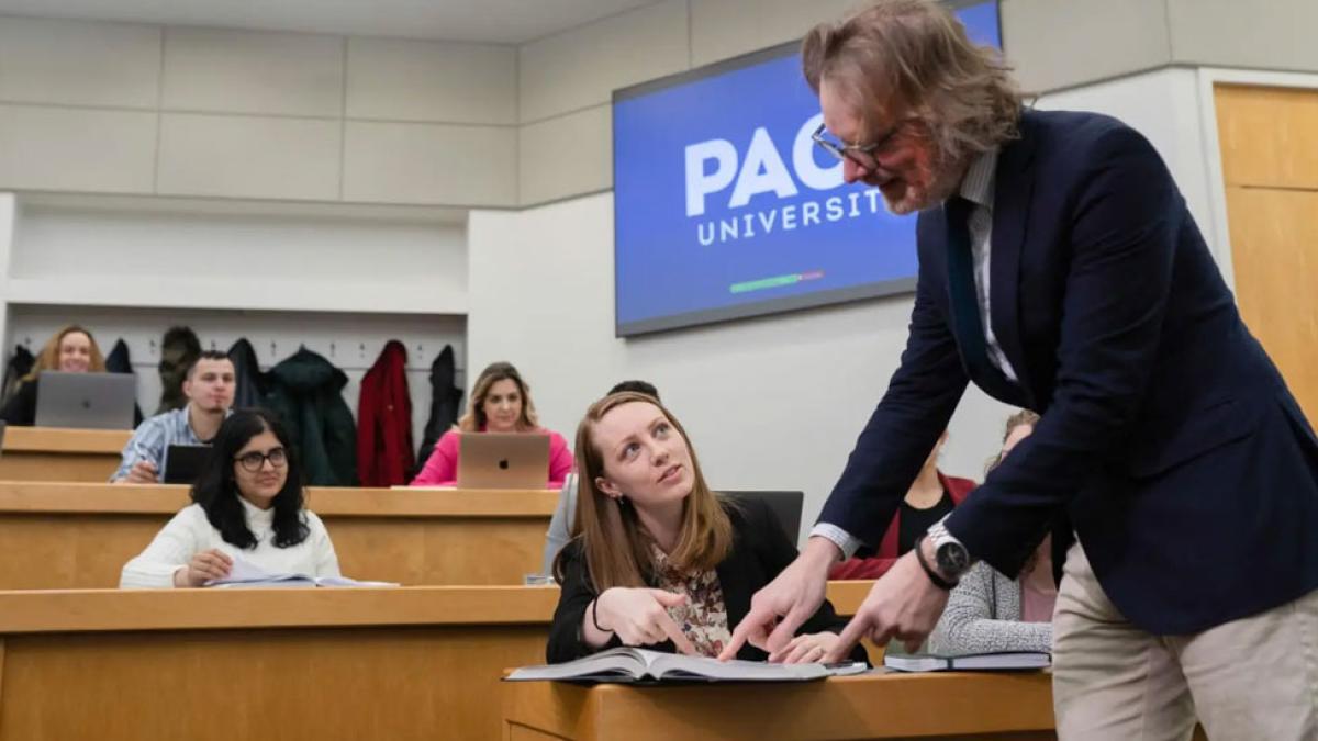 A faculty member working with students in a Haub Law classroom.
