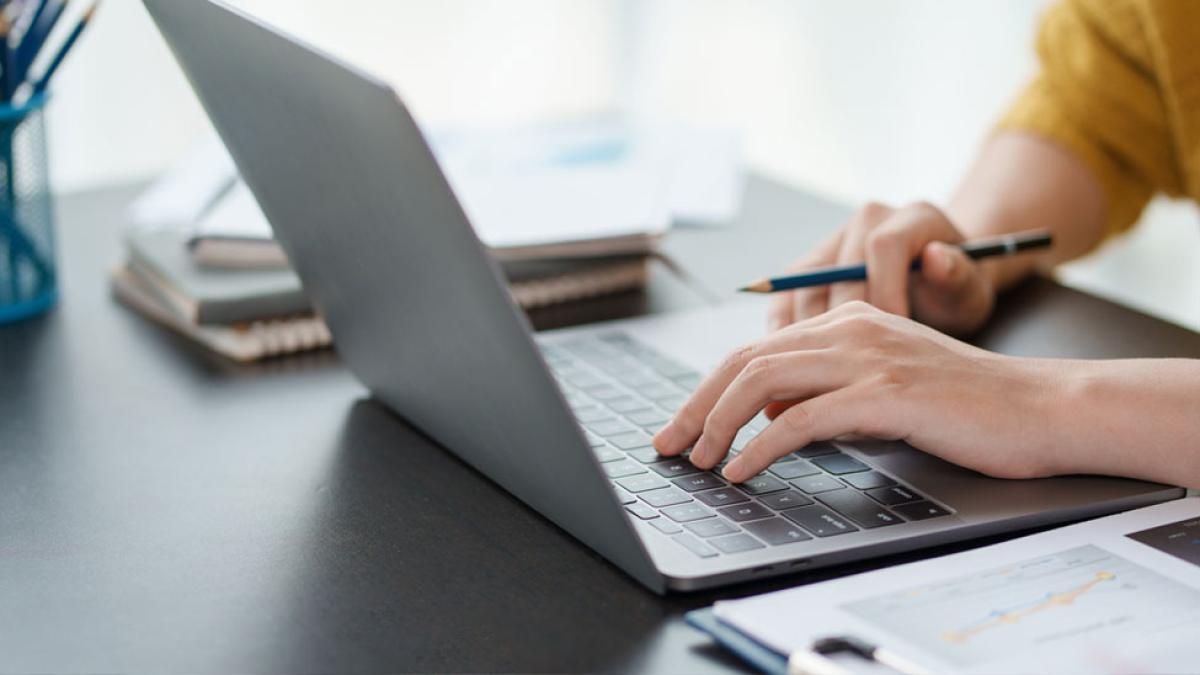 Person typing on their laptop.