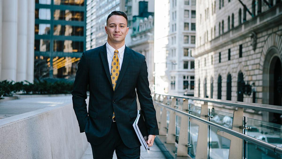 Pace University student dressed in business attire smiling at the camera in NYC.