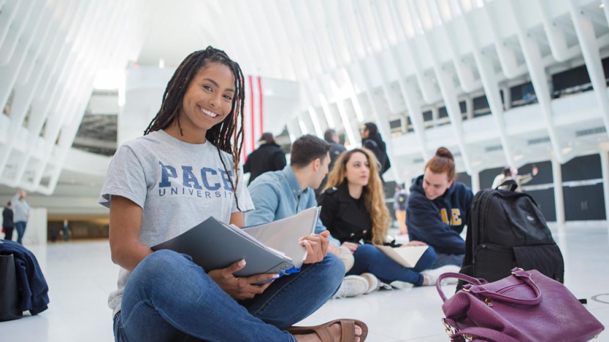 Pace University student reading a book in the Westfield World Trade Center in Manhattan.
