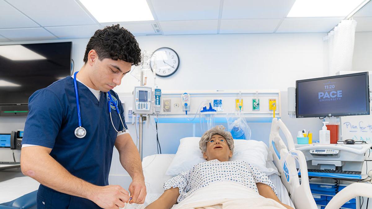 Student from the College of Health Professions at Pace University working with a training dummy