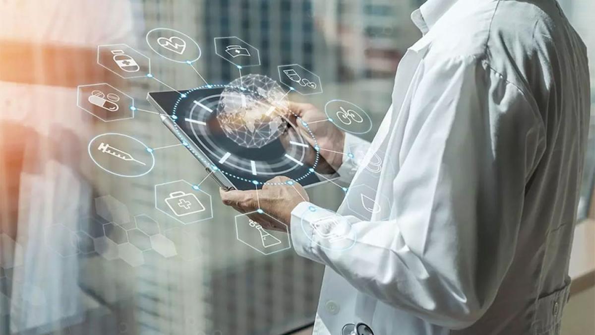A healthcare professional wearing a white coat uses a digital tablet displaying holographic medical icons and a glowing globe, symbolizing health informatics.