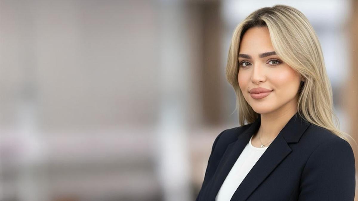 Pace University student Rafad Shlla wears a blazer and smiles at the camera