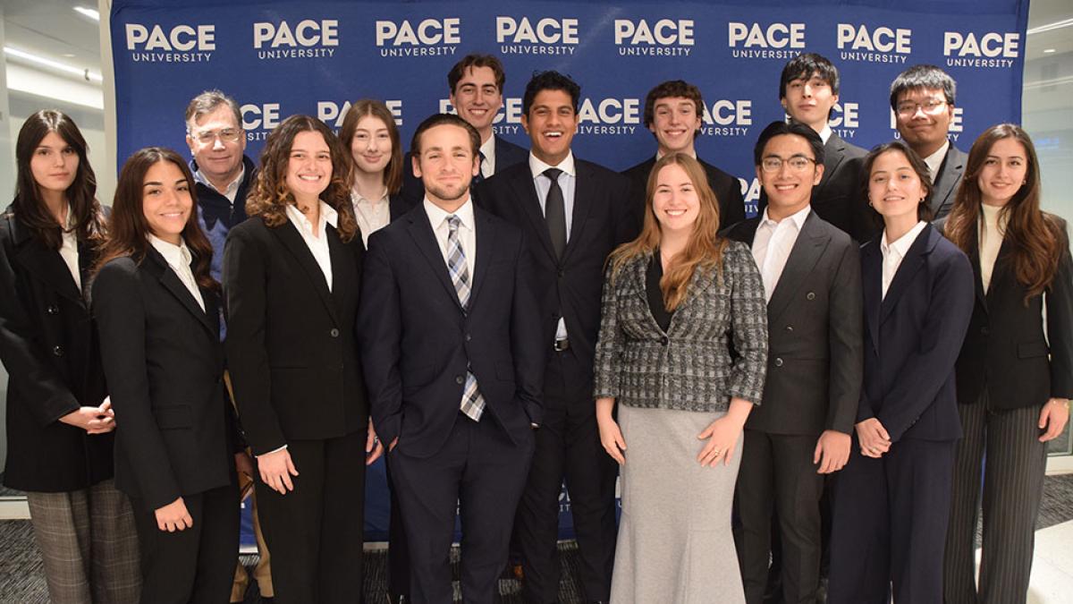Pace University Federal Reserve Challenge Team winners standing together with Pace media banner in background