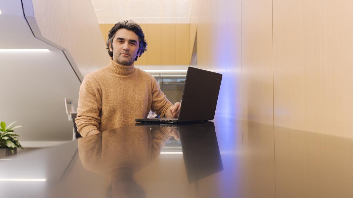 Lubin student sitting at a laptop in a student lounge on the New York City campus