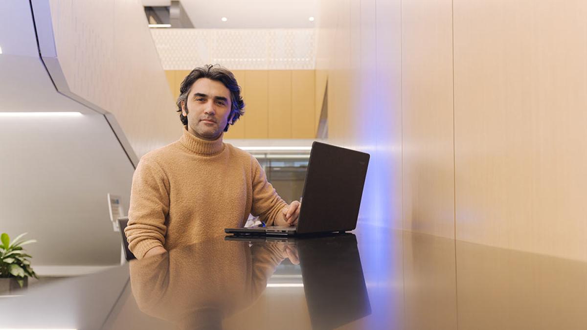 Lubin student sitting at a laptop in a student lounge on the New York City campus