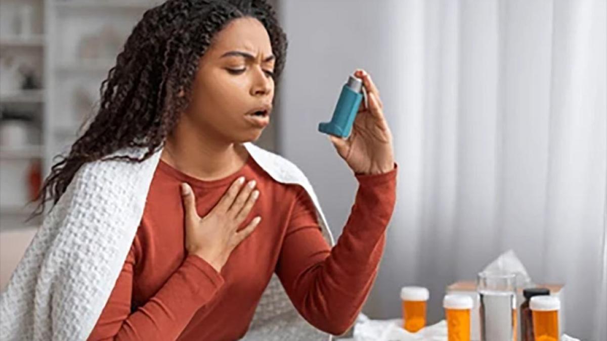 woman using an asthma inhaler